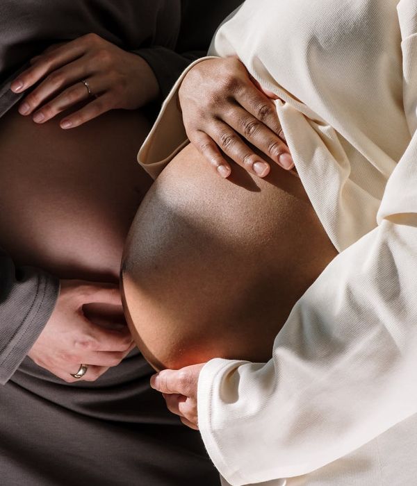 Close-up of a pregnant woman's hands resting on her belly.